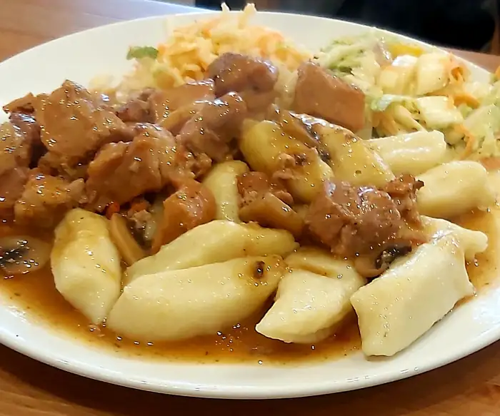 Mięso w sosie z kluskami i surówką