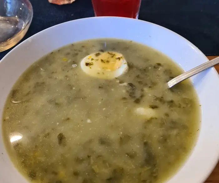 Talerz zupy z połówką jajka, obok kompot